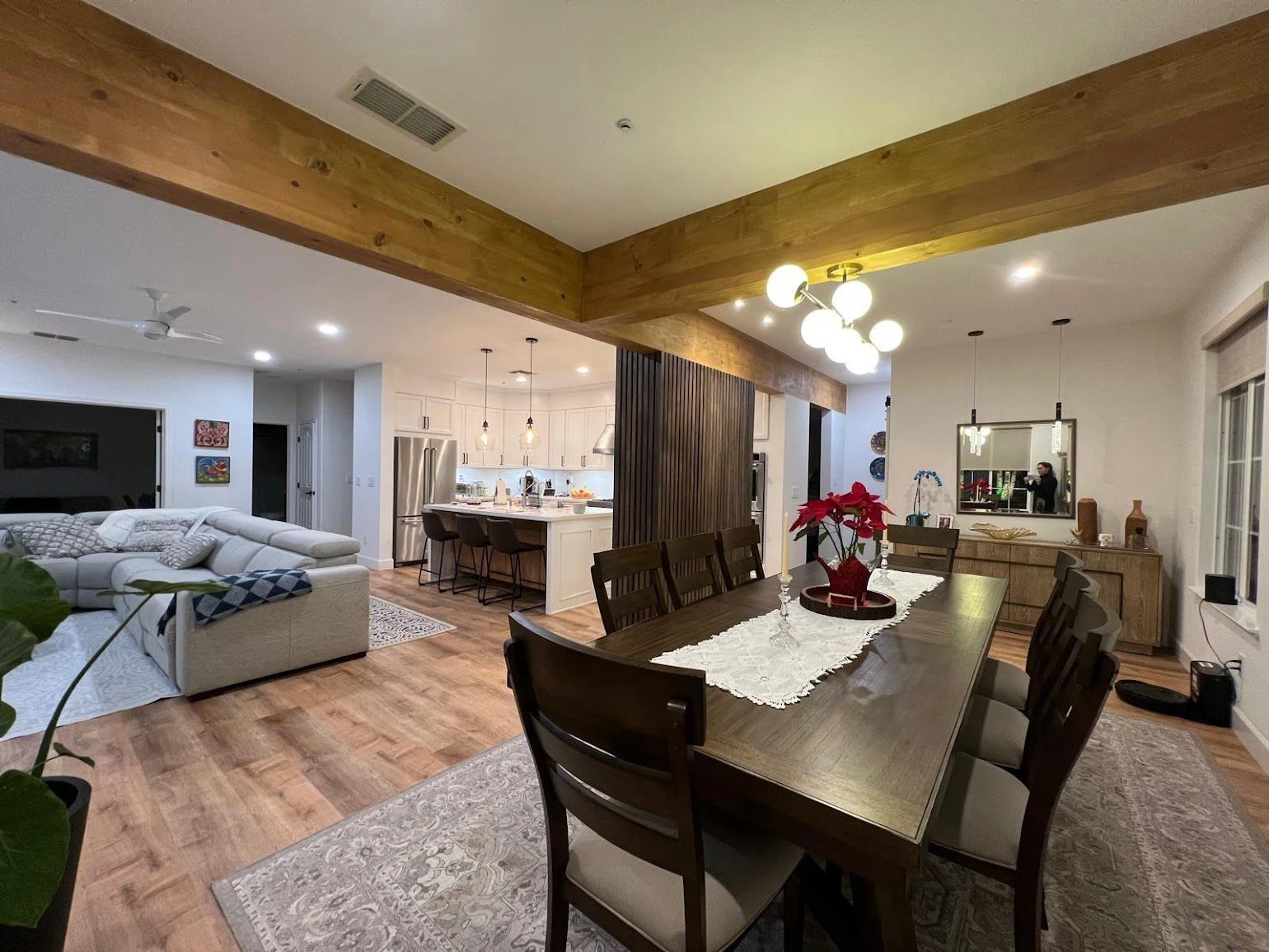 Whole home remodel in the Bay Area: living room, dining room and kitchen opened into one space under exposed wood beams